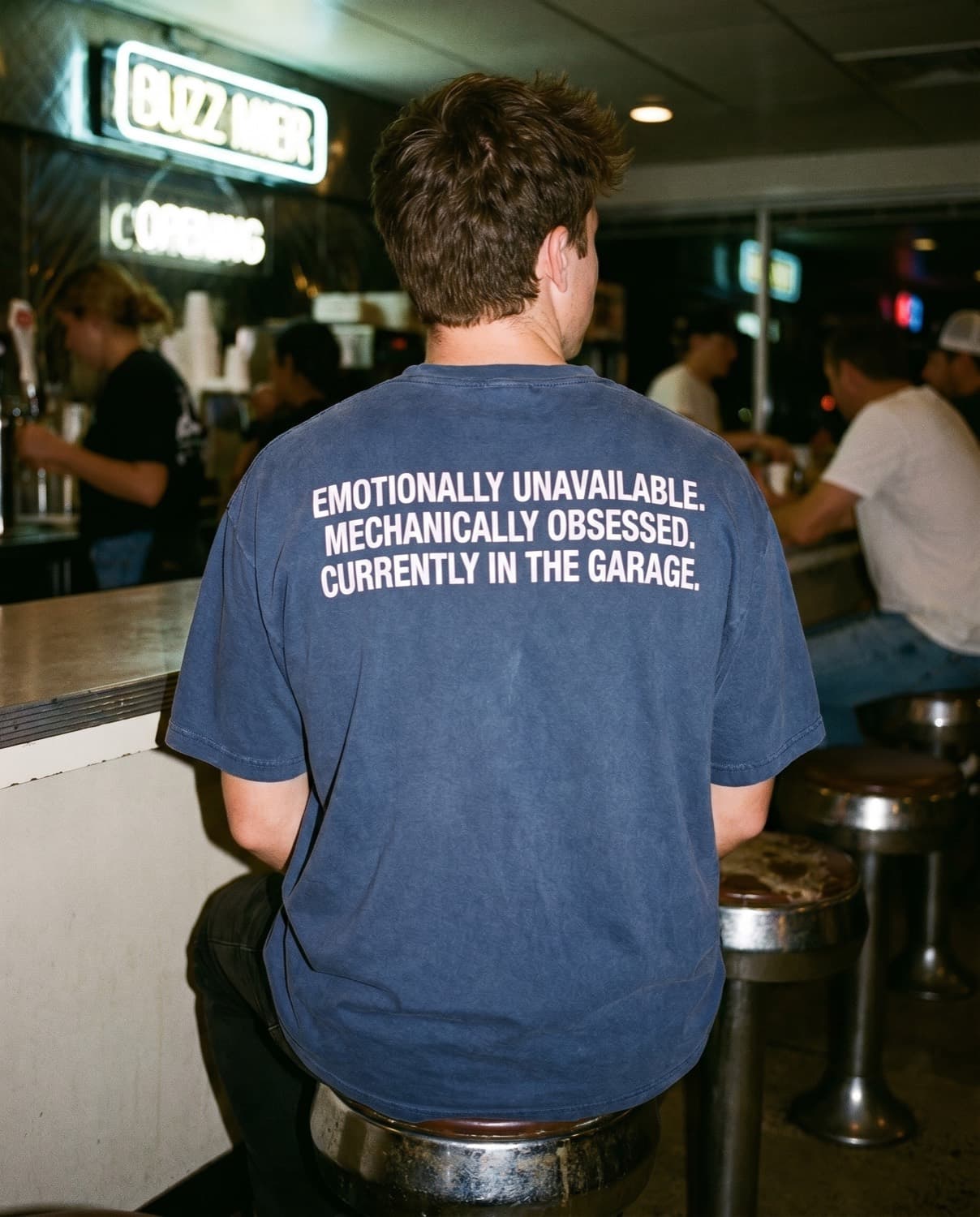 Back view of the "EMOTIONALLY UNAVAILABLE. MECHANICALLY OBSESSED. CURRENTLY IN THE GARAGE." tee